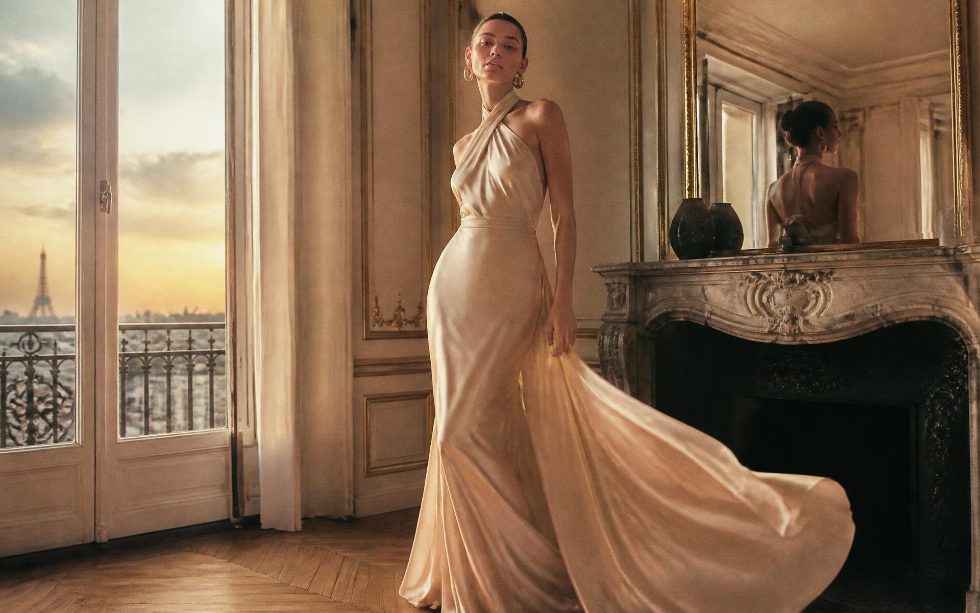 Model in a champagne silk evening gown in a Parisian salon at dusk